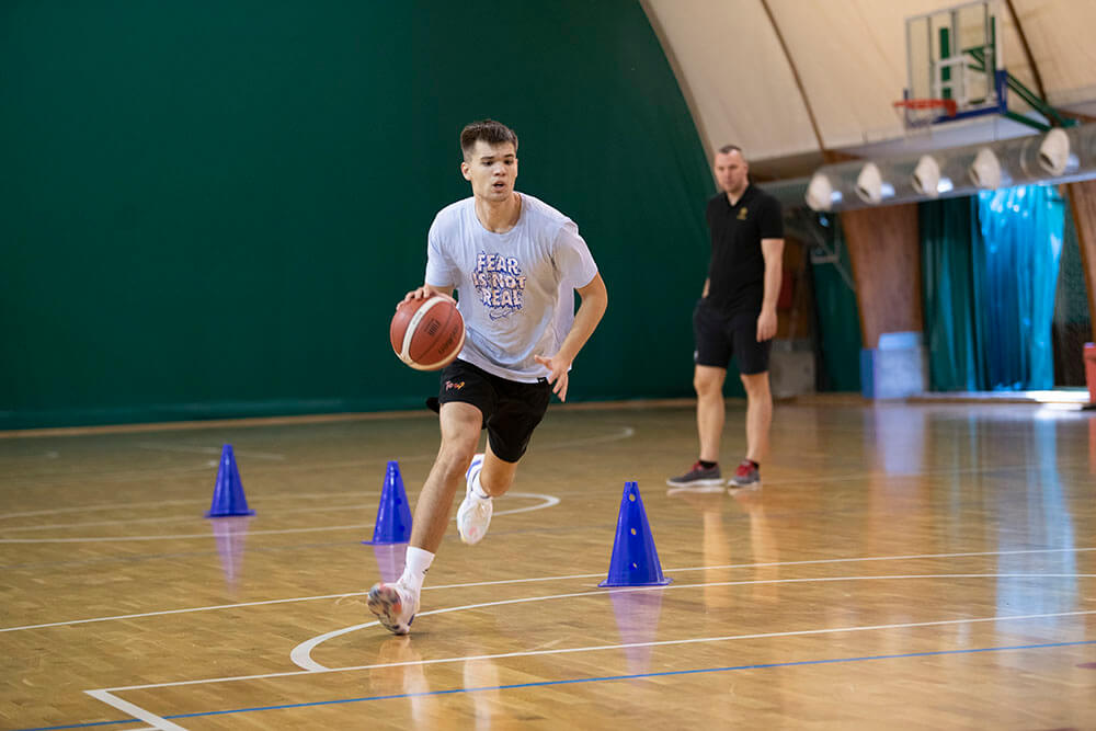 dečak uči košarkaško kretanje i promenu pravca sa loptom