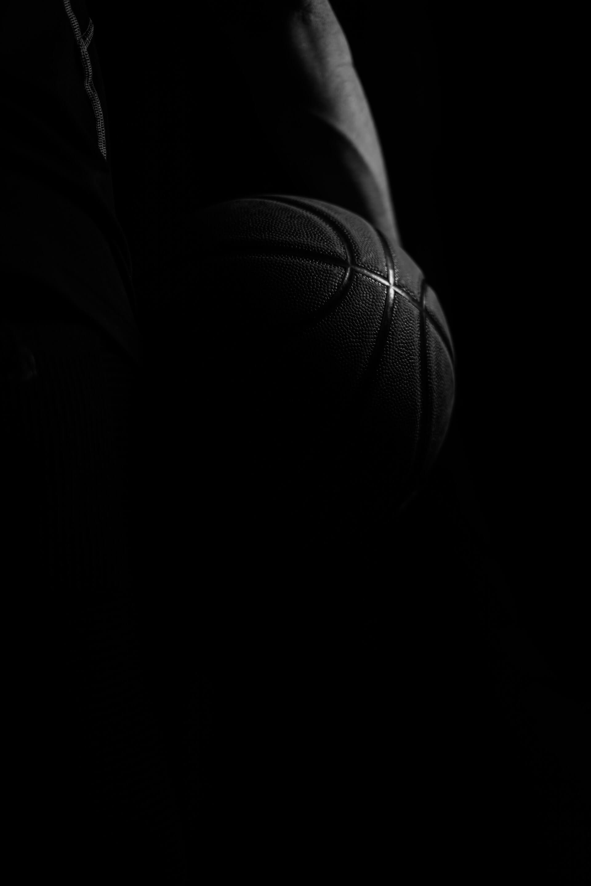čovek drži košarkašku loptu